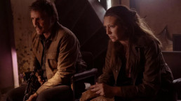 Plan sur Joel et Tess, incarnés par Pedro Pascal et Anna Torv dans la série The Last of Us. Ils semblent attendrent à l'intérieur d'un bâtiment. Joel a un fusil dans les mains.