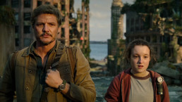 Image tirée de la série The Last of Us (HBO). Plan serré sur Joel et Ellie (Pedro Pascal et Bella Ramsey), qui regarde devant eux (vers la caméra) depuis les toits de Boston.
