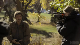 Photo des coulisses de la série The Last of Us (HBO). On voit Pedro Pascal (Joel) en extérieur, devant la caméra.