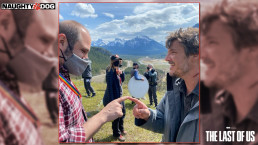 Craig Mazin et Pedro Pascal sur le tournage de la série The Last of Us (HBO). Ils sont en extérieur, visiblement dans les hauteurs des montagnes. Il faut jour, le ciel est un peu nuageux. Les deux hommes se tiennent face à face et touchent chacun l'index de l'autre avec leur propre index. Des membres de l'équipe de tournage sont visibles en arrière-plan.