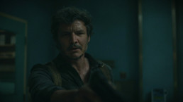 Gros plan sur Joel (Pedro Pascal) dans un bloc opératoire. L'air sérieux, déterminé, il pointe son pistolet devant lui. (The Last of Us HBO, S01E09, 2023)