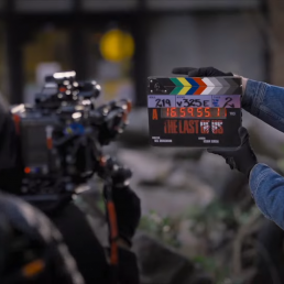 Photo du tournage de la série The Last of Us (HBO). Une caméra est prête à tourner tandis que le clap se referme devant elle.